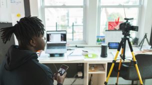 Imagem de um músico criando com ferramentas como Canva, destacando a importância de designs visuais profissionais no marketing musical.